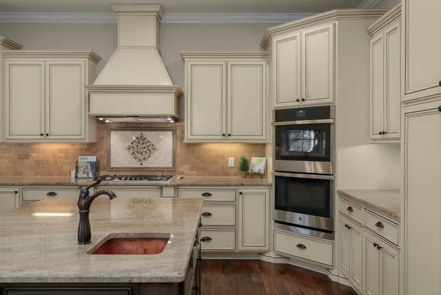 a kitchen with granite countertop a stove a sink and a microwave