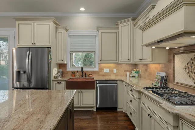 a kitchen with stainless steel appliances granite countertop a stove a sink dishwasher and a refrigerator