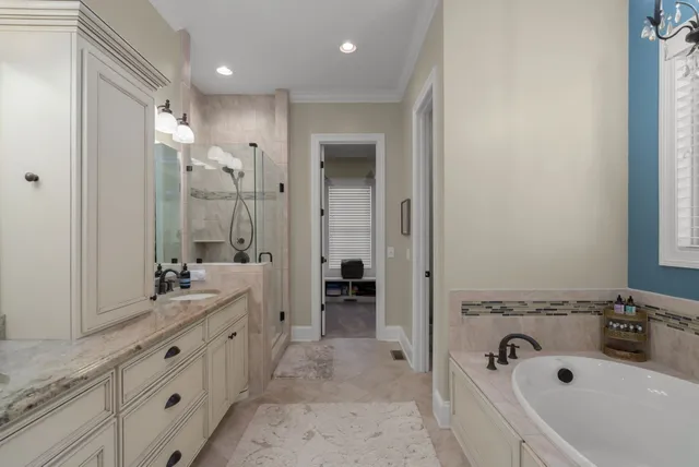 a bathroom with a tub sink double vanity and mirror