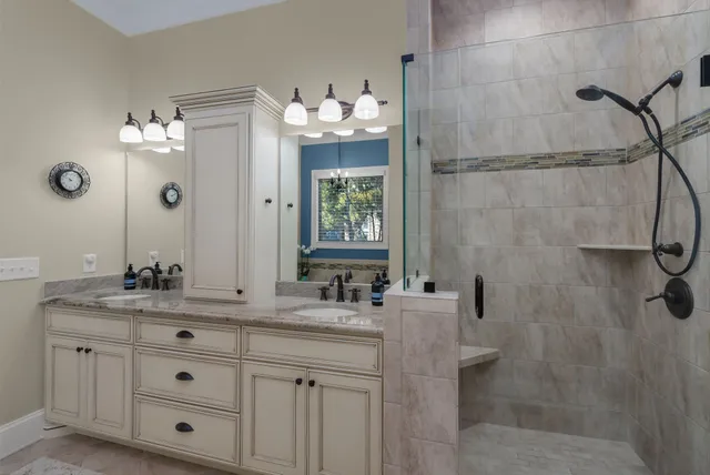 a bathroom with a double vanity sink mirror and shower