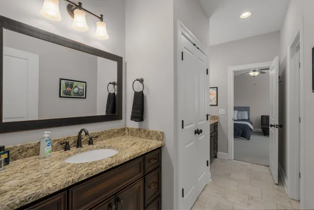 a bathroom with a granite countertop sink and a mirror