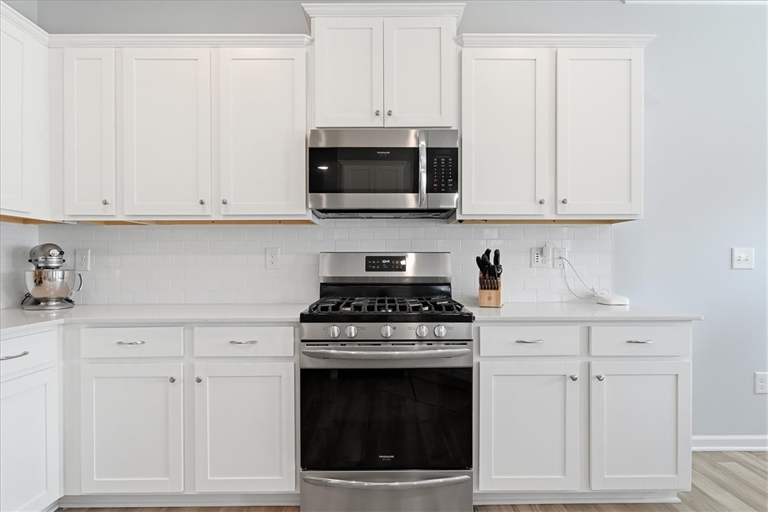 208 Grassy Creek Way Pendleton, SC 29670 - Photo 16 of 43 A well-appointed kitchen showcasing contemporary white cabinetry and sleek stainless steel appliances.