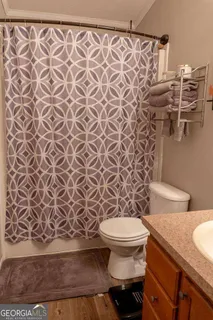 a bathroom with a toilet and a shower curtain
