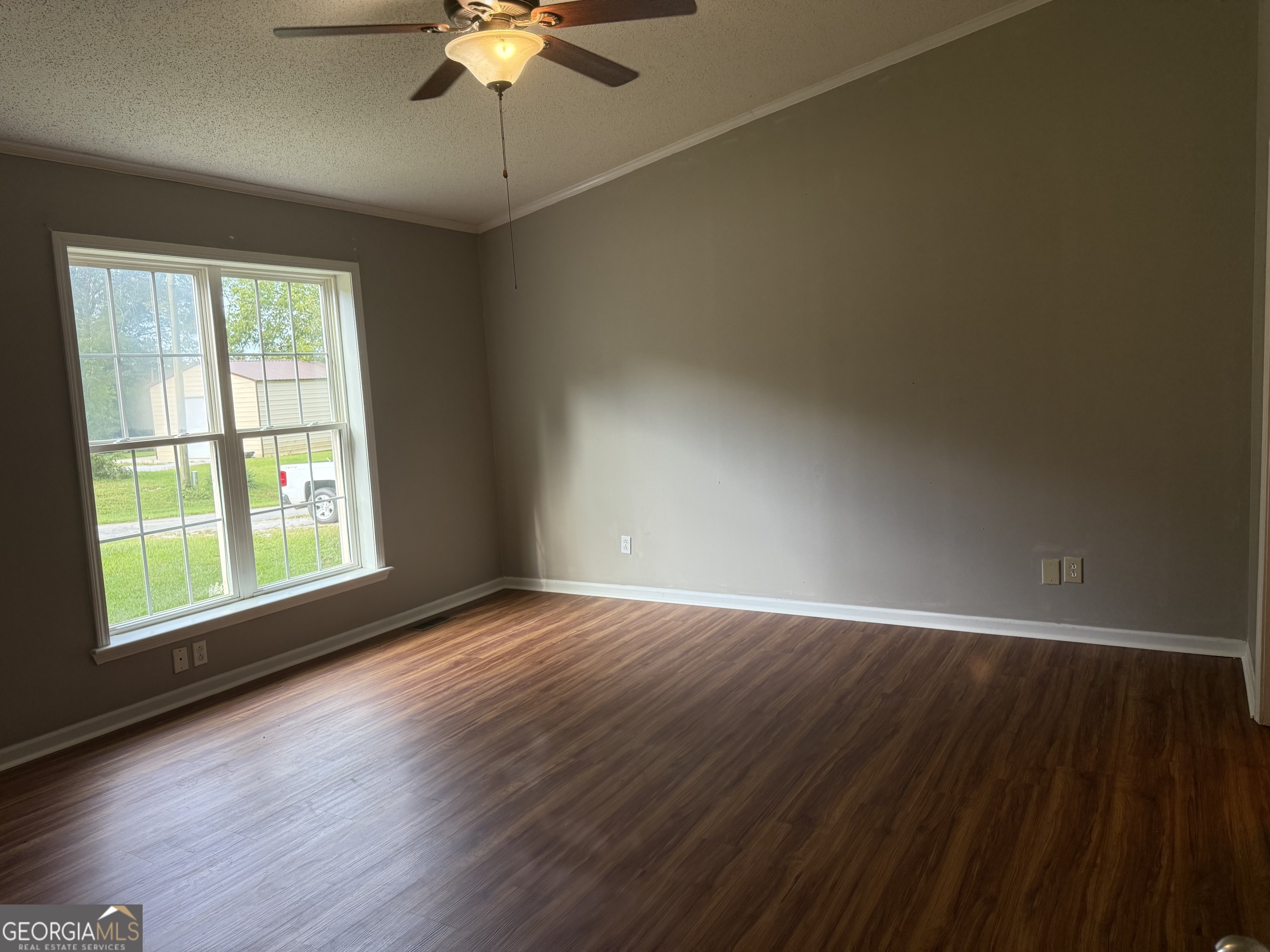 714 Yates Road Bowdon, GA 30108 - Photo 25 of 28 an empty room with wooden floor chandelier fan and windows