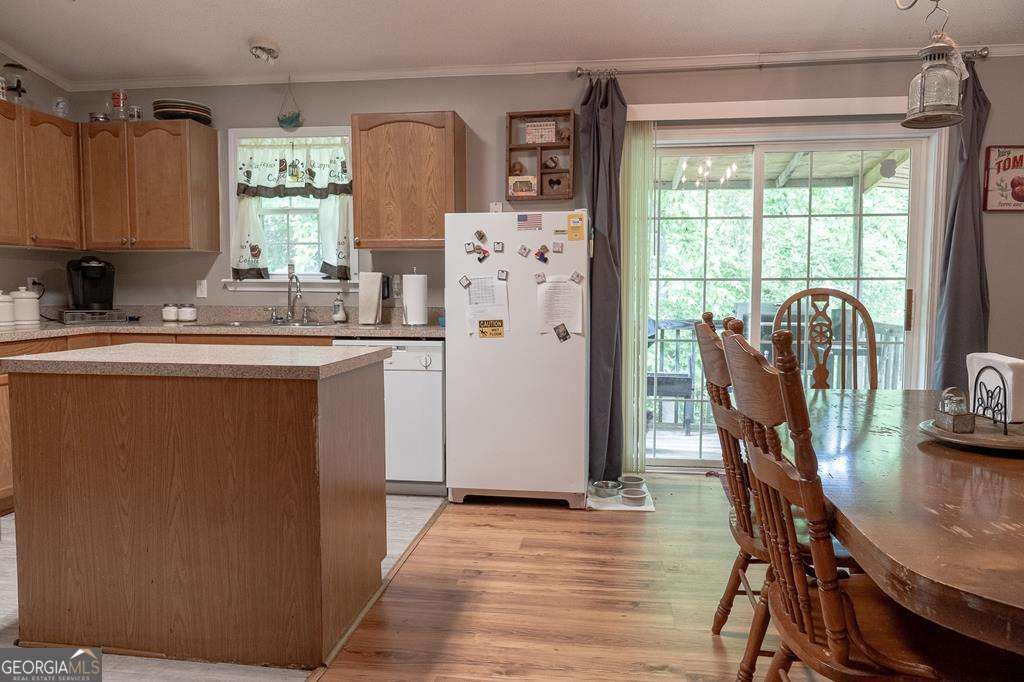 714 Yates Road Bowdon, GA 30108 - Photo 6 of 28 a kitchen with stainless steel appliances granite countertop a refrigerator a sink dishwasher a dining table and chairs with wooden floor