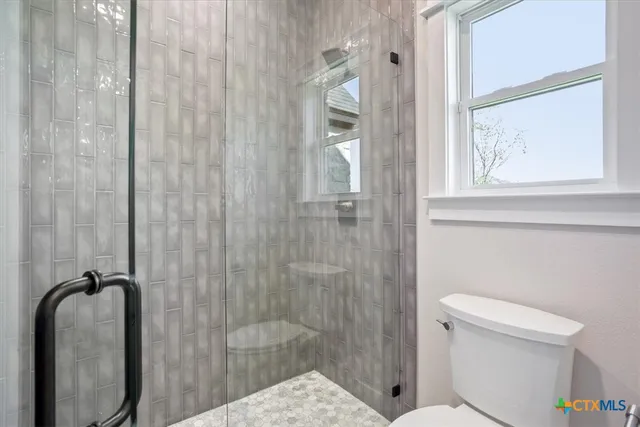 a bathroom with a shower and toilet