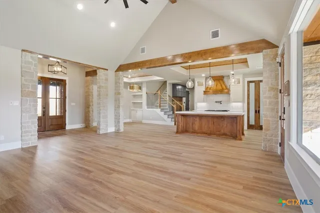 a view of a hallway with wooden floor and a bathroom