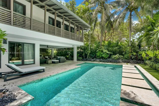 a view of a house with swimming pool and sitting area