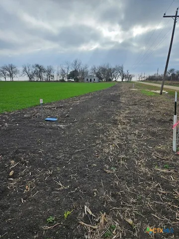a view of a big yard with an trees in the background
