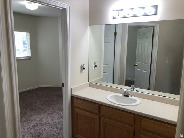 4791 West Barletta Street South West Jordan, UT 84084 - Photo 10 of 10 Single vanity with a laminate countertop, integrated sink, and wood-finish cabinetry