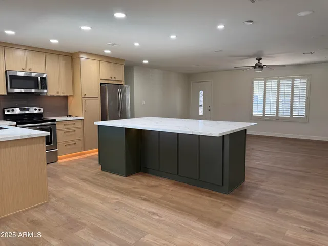 a kitchen with stainless steel appliances granite countertop a sink a stove a refrigerator and a microwave