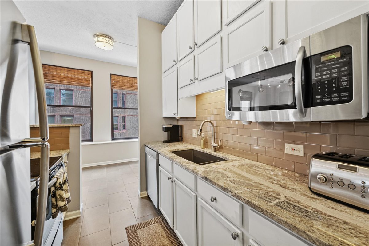 600 South Dearborn Street, Unit 601 Chicago, IL 60605 - Photo 11 of 18 a kitchen with stainless steel appliances granite countertop a sink stove and cabinets