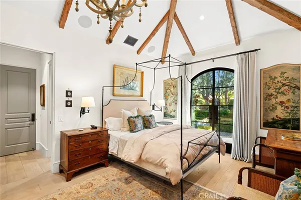 a bedroom with a bed and a chandelier