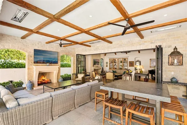 a living room with furniture a fireplace and floor to ceiling windows