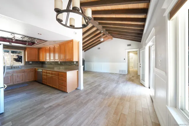 a kitchen with stainless steel appliances kitchen island wooden floors granite counter tops and a window