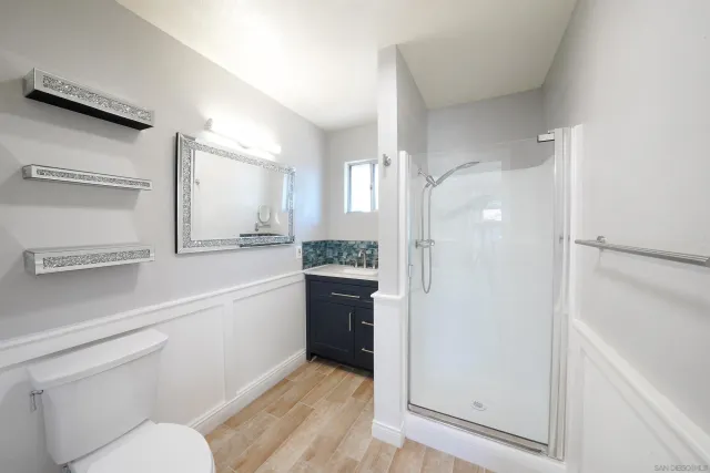 a bathroom with a sink a toilet and shower