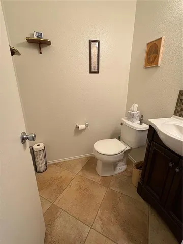a bathroom with a granite countertop toilet and a sink