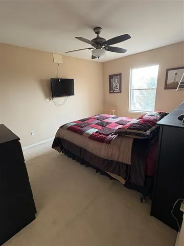 a bedroom with a bed and a ceiling fan