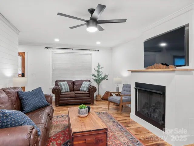 a living room with furniture a flat screen tv and a fireplace