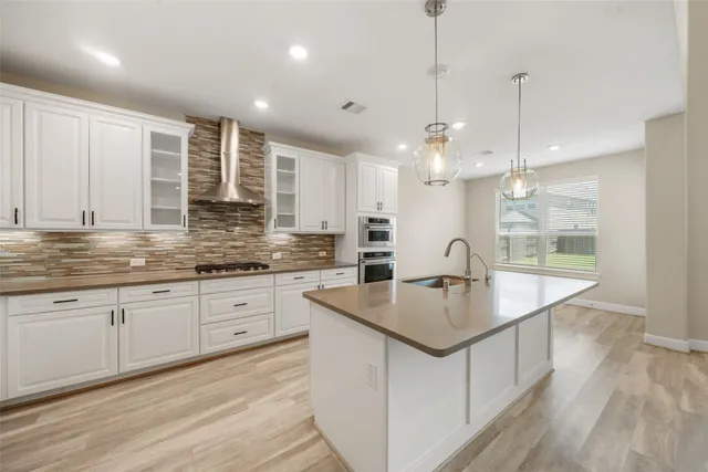 a kitchen with kitchen island a sink a counter space appliances and cabinets