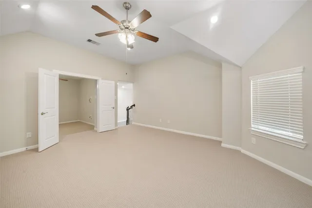 an empty room with a ceiling fan and a window