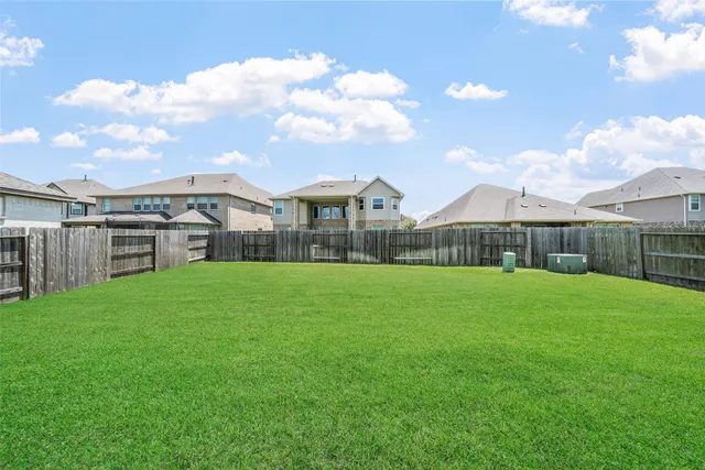 a view of a big house with a big yard and large trees