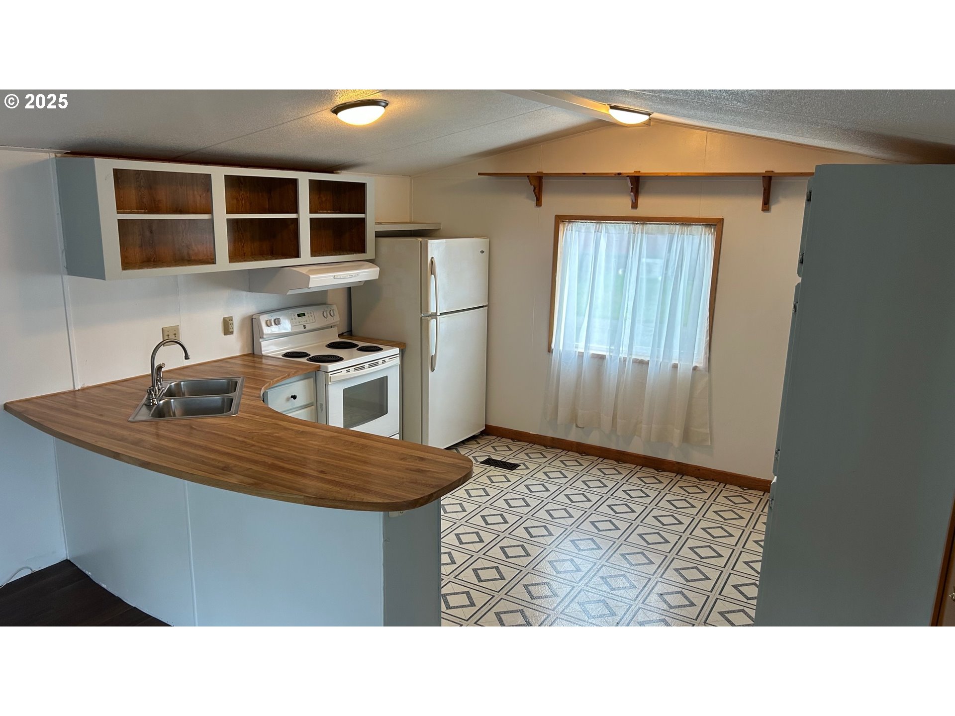 91323 Sandstone Lane, Unit 418 Coos Bay, OR 97420 - Photo 2 of 20 a kitchen with a sink a refrigerator and cabinets