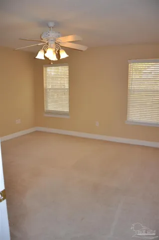 en empty room with windows and chandelier