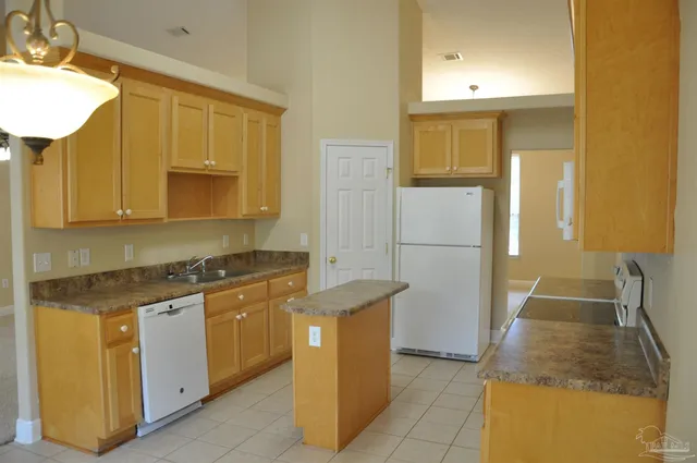 a kitchen with stainless steel appliances granite countertop a sink and a refrigerator