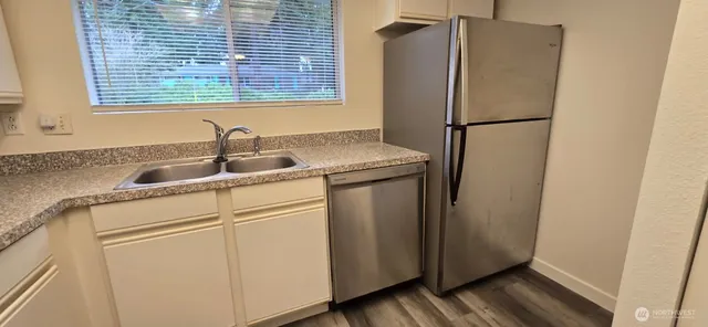 a kitchen with stainless steel appliances granite countertop a refrigerator and a sink