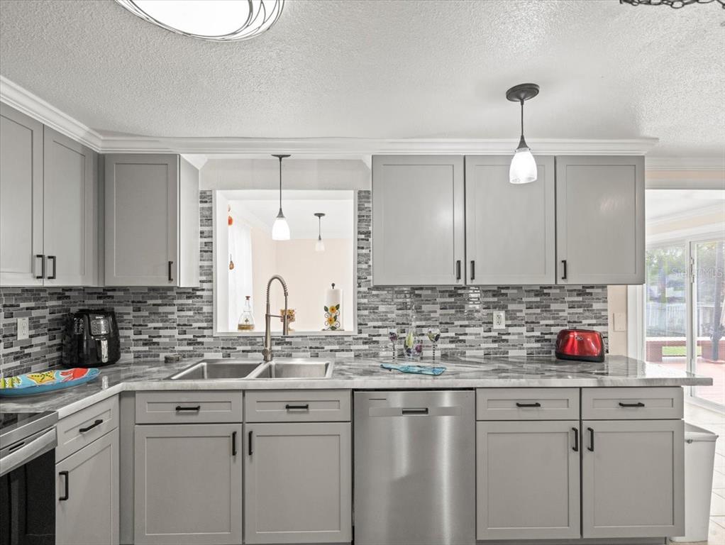 3408 Crape Myrtle Drive Hernando Beach, FL 34607 - Photo 11 of 46 a kitchen with stainless steel appliances granite countertop a sink a stove and cabinets