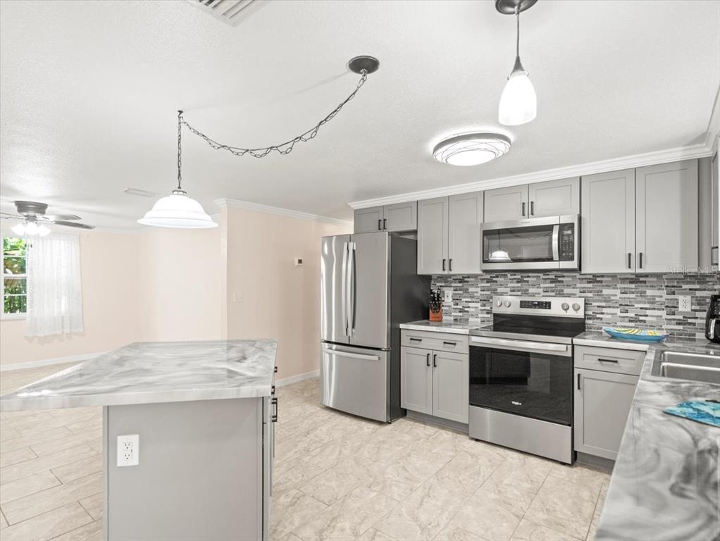 3408 Crape Myrtle Drive Hernando Beach, FL 34607 - Photo 14 of 46 a kitchen with stainless steel appliances granite countertop a stove a refrigerator and a sink