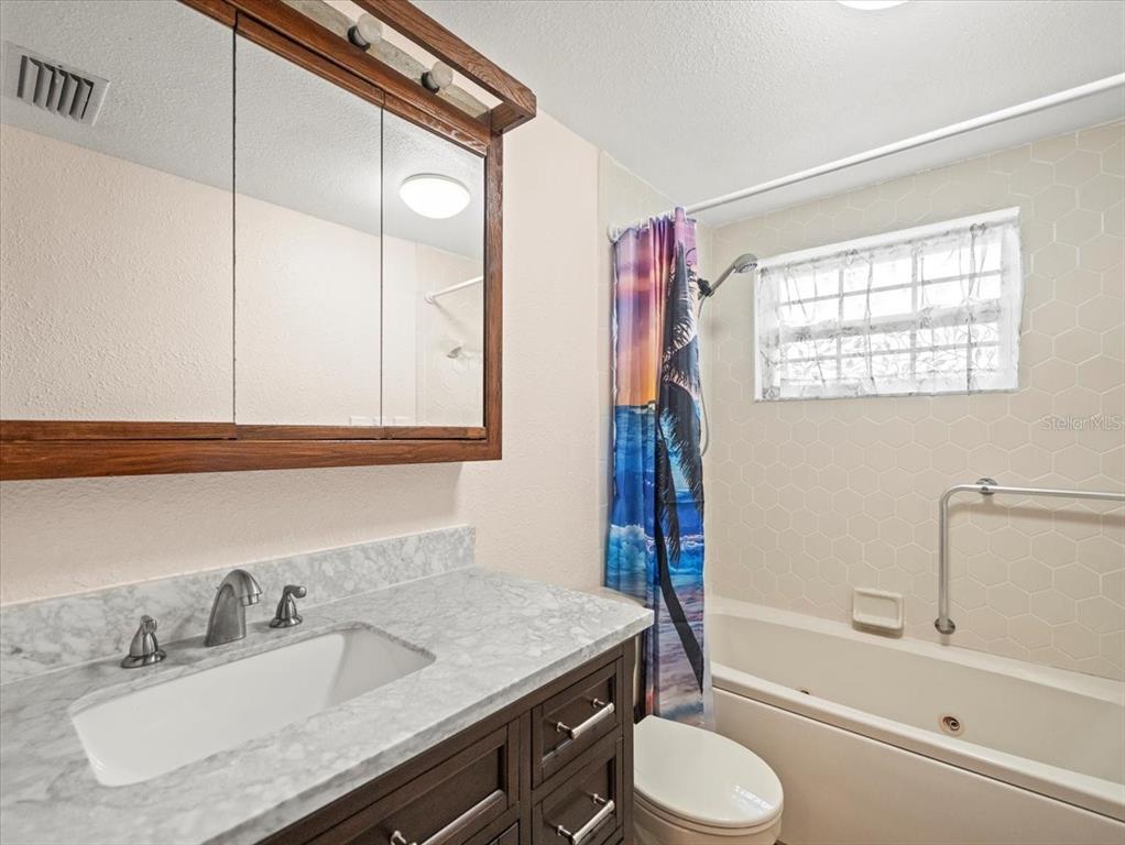 3408 Crape Myrtle Drive Hernando Beach, FL 34607 - Photo 21 of 46 a bathroom with a granite countertop sink toilet and shower
