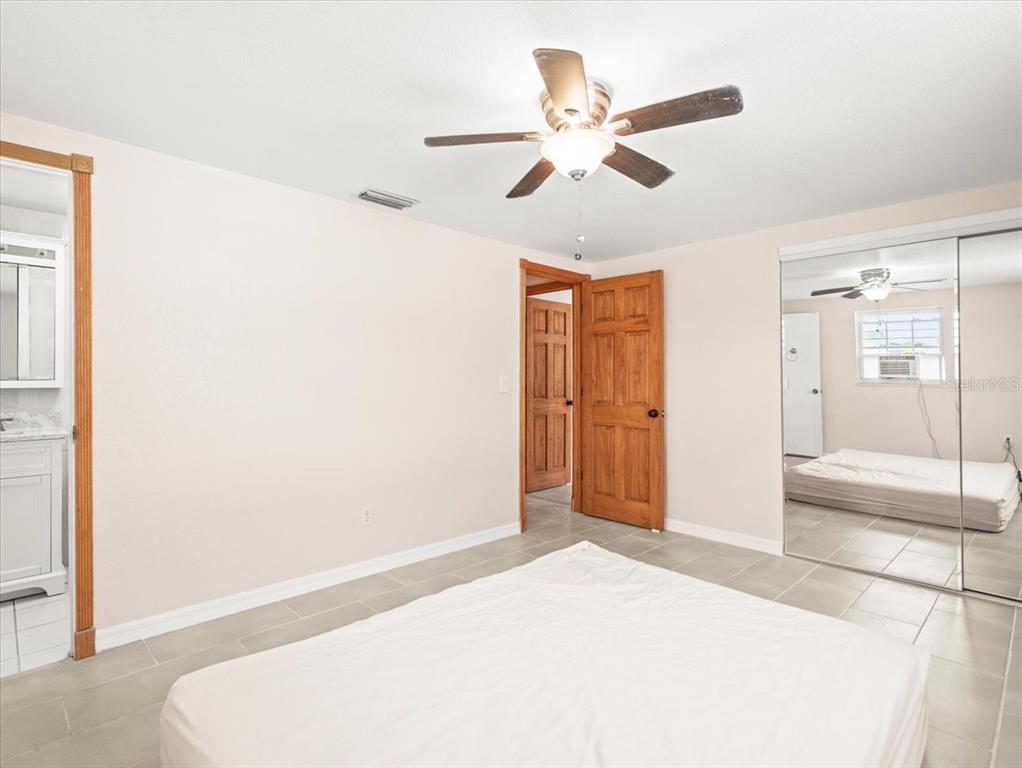 3408 Crape Myrtle Drive Hernando Beach, FL 34607 - Photo 26 of 46 a bedroom with a large bed and a chandelier fan