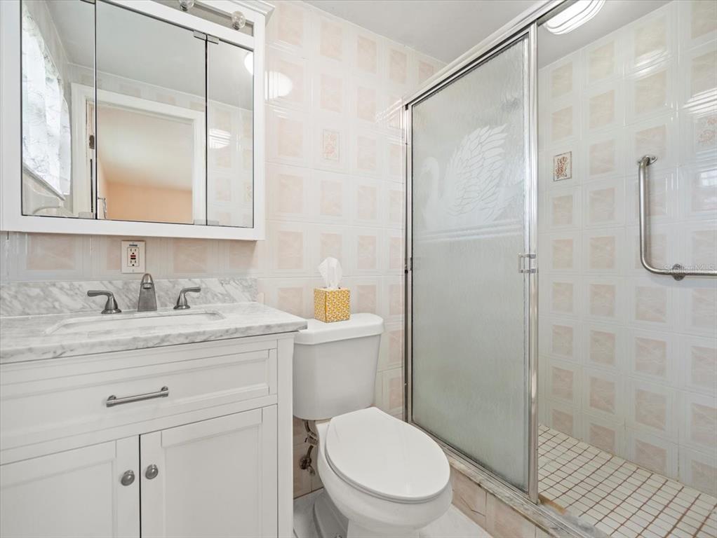 3408 Crape Myrtle Drive Hernando Beach, FL 34607 - Photo 27 of 46 a bathroom with a granite countertop sink toilet a mirror and shower
