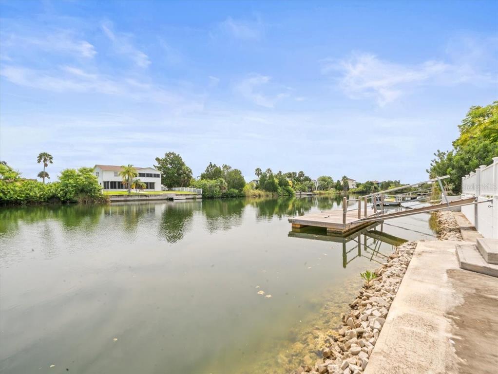 3408 Crape Myrtle Drive Hernando Beach, FL 34607 - Photo 34 of 46 a view of a lake with a table and chairs under an umbrella
