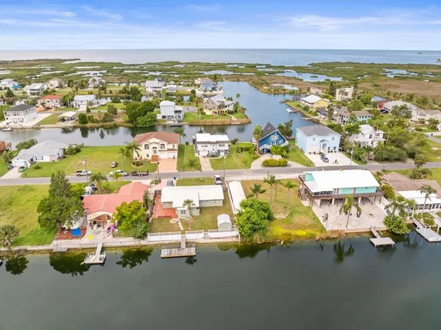 an aerial view of residential houses with outdoor space and ocean view