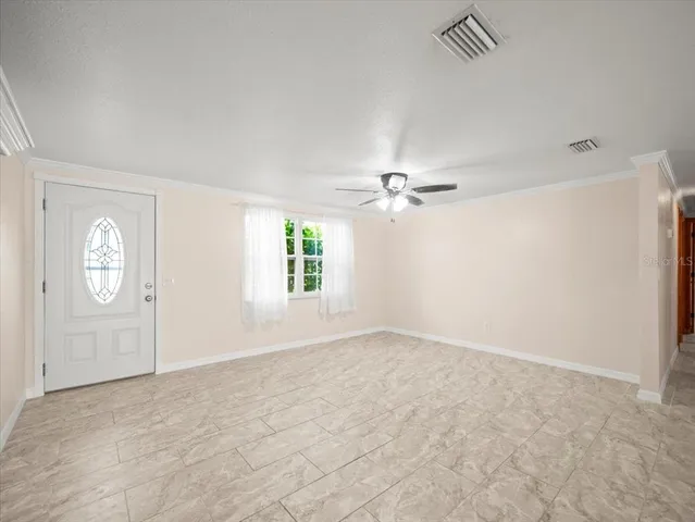 an empty room with windows and fan