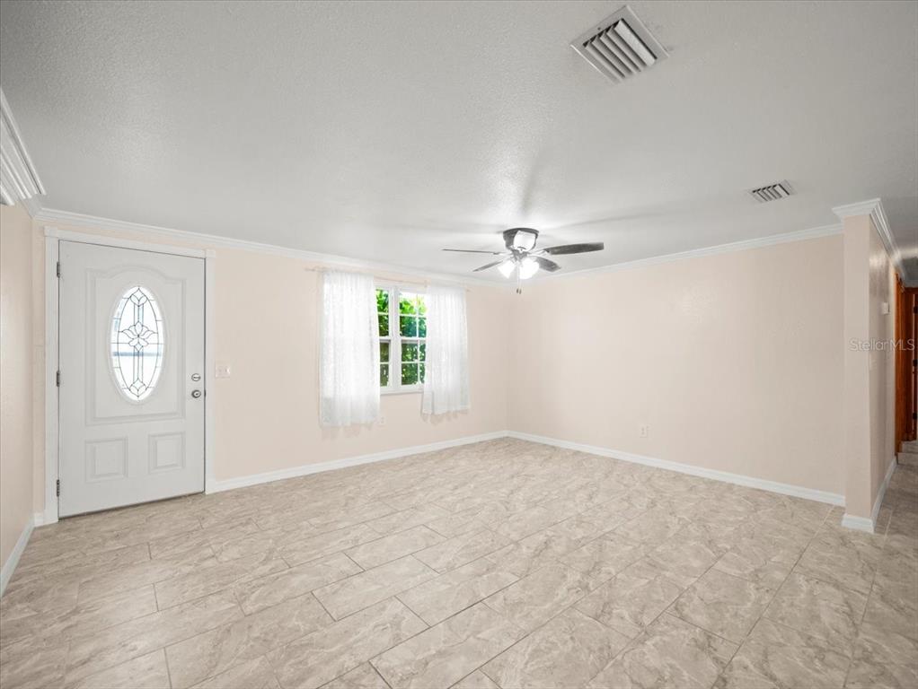 3408 Crape Myrtle Drive Hernando Beach, FL 34607 - Photo 6 of 46 an empty room with windows and fan