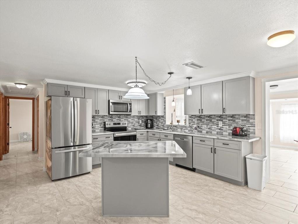 3408 Crape Myrtle Drive Hernando Beach, FL 34607 - Photo 9 of 46 a kitchen with stainless steel appliances granite countertop a refrigerator a stove a sink and a refrigerator