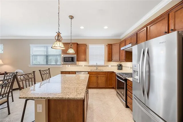 a kitchen with stainless steel appliances granite countertop a refrigerator a stove and a wooden floors