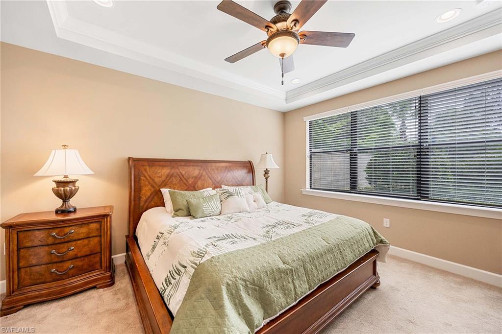 7638 Jacaranda Lane Naples, FL 34114 - Photo 20 of 50 a bedroom with a bed and a chandelier