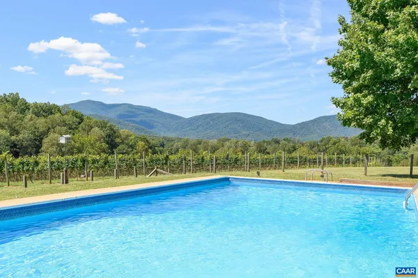 an aerial view of a house with a yard and lake view