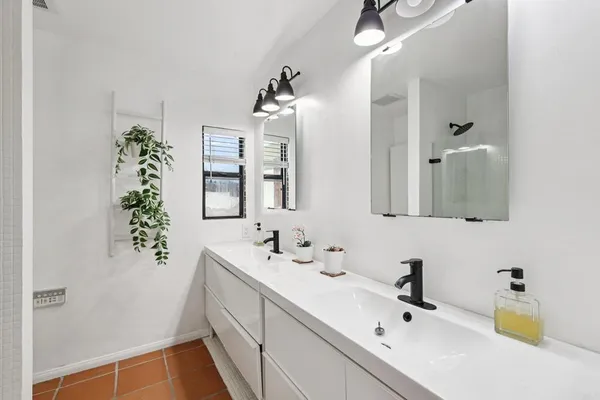 a bathroom with a sink vanity tub and shower