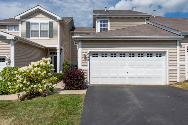a front view of a house with a yard and garage