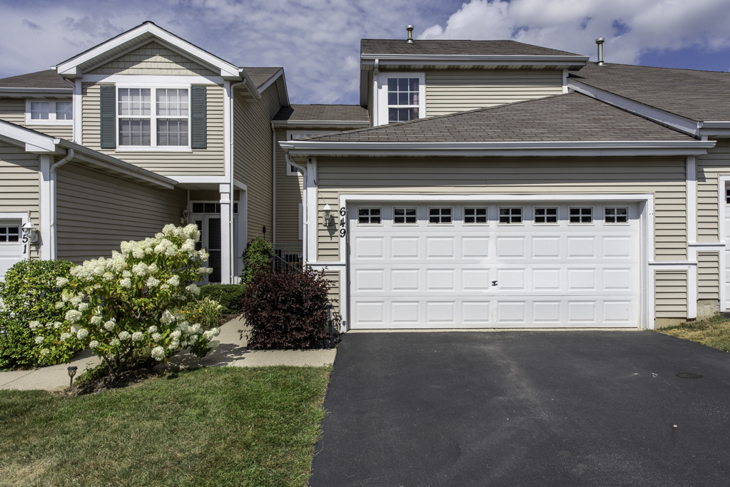 a front view of a house with a yard and garage