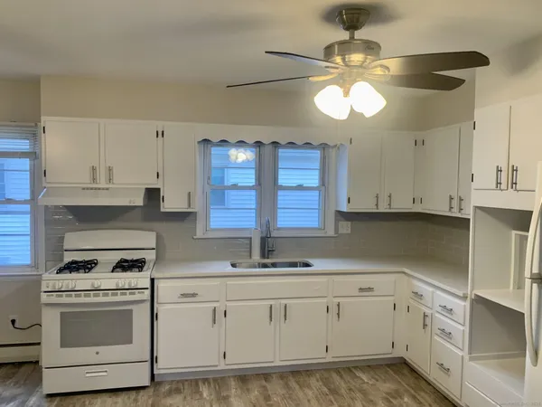 a kitchen with cabinets appliances a sink and a window