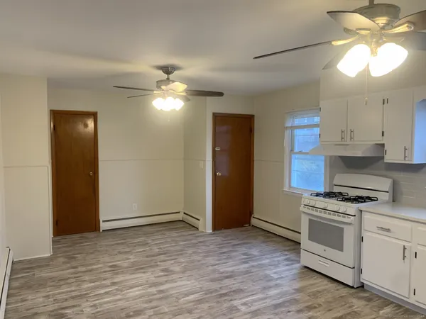 a kitchen with granite countertop a stove a sink and a refrigerator