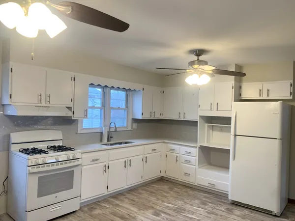 a kitchen with a sink cabinets stainless steel appliances and a window
