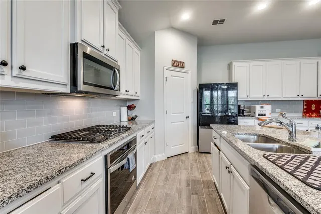 a kitchen with kitchen island granite countertop white cabinets and white appliances